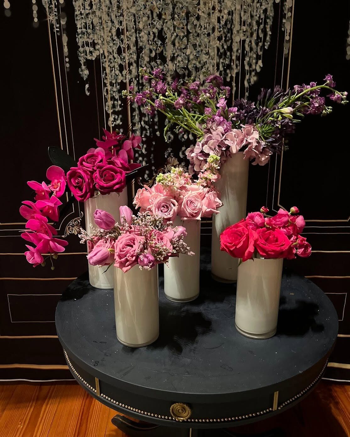 Collection of bud vases in fuchsia, lavender, and pink with orchids, roses, and tulips